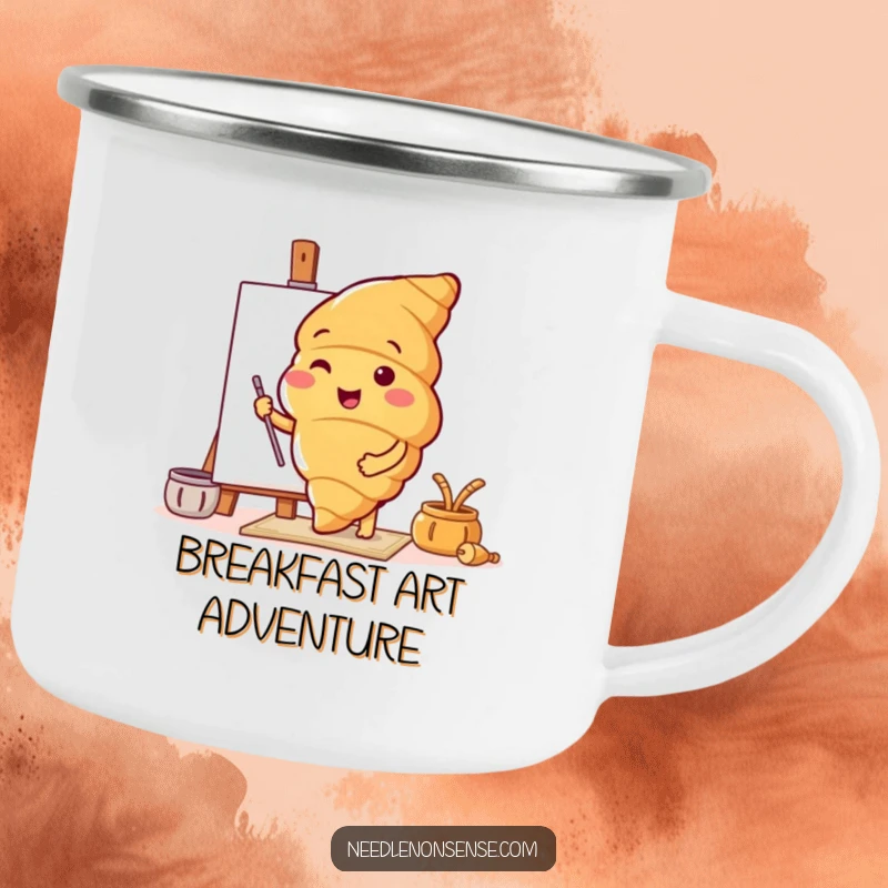 Funny enamel camping mug featuring a croissant character preparing a canvas, perfect for artists who enjoy the outdoors.