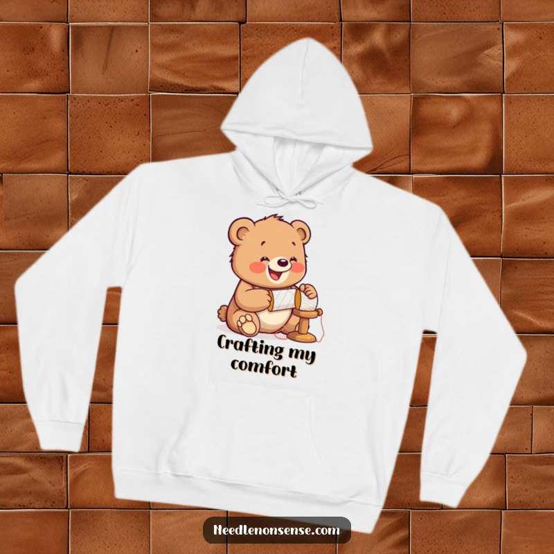 Funny Bear Sewing Hoodie, featuring a jolly cub hammering a spool, wearing a thimble, embodying cozy crafting power.