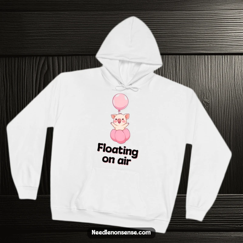Funny kawaii piglet smiling and floating upwards on a balloon, a humorous and cozy design on this hoodie, perfect for relaxation.