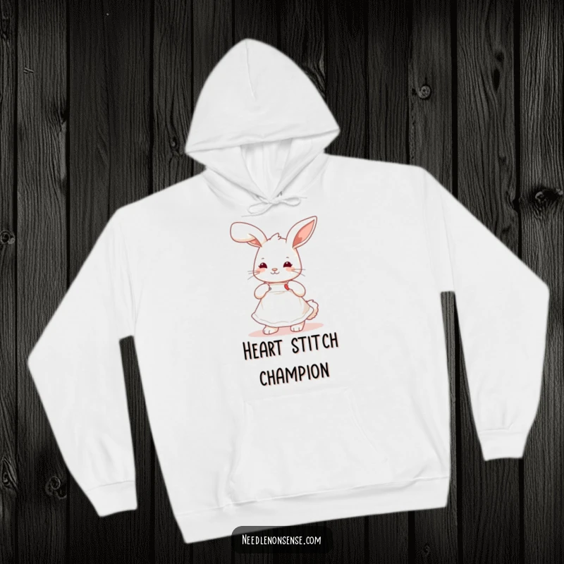 Funny playful bunny wearing a cute apron, stitching a tiny heart, a comfortable and humorous hoodie for crafters.