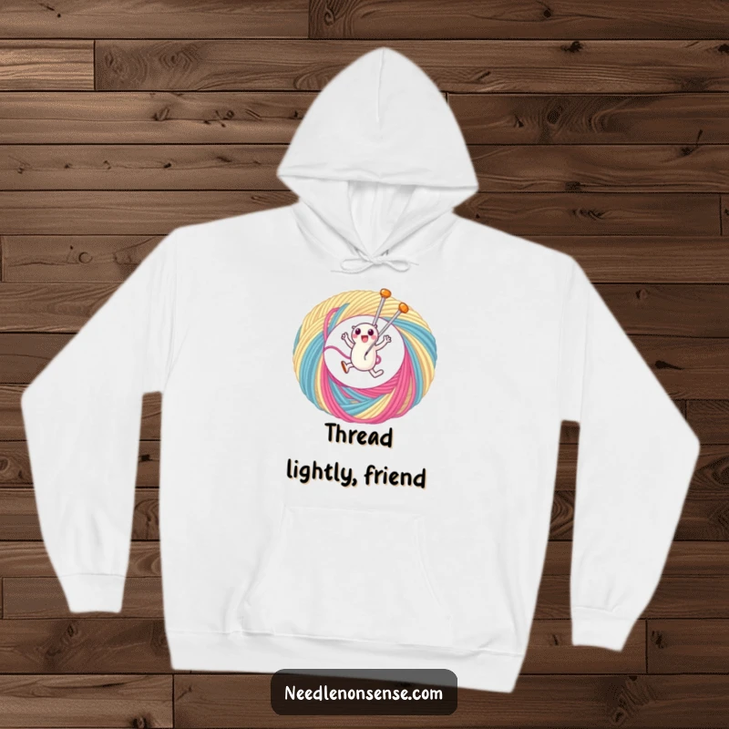 Funny hoodie depicting a spirited needle character mid-leap through a vibrant, oversized loop of thread, perfect for sewists.
