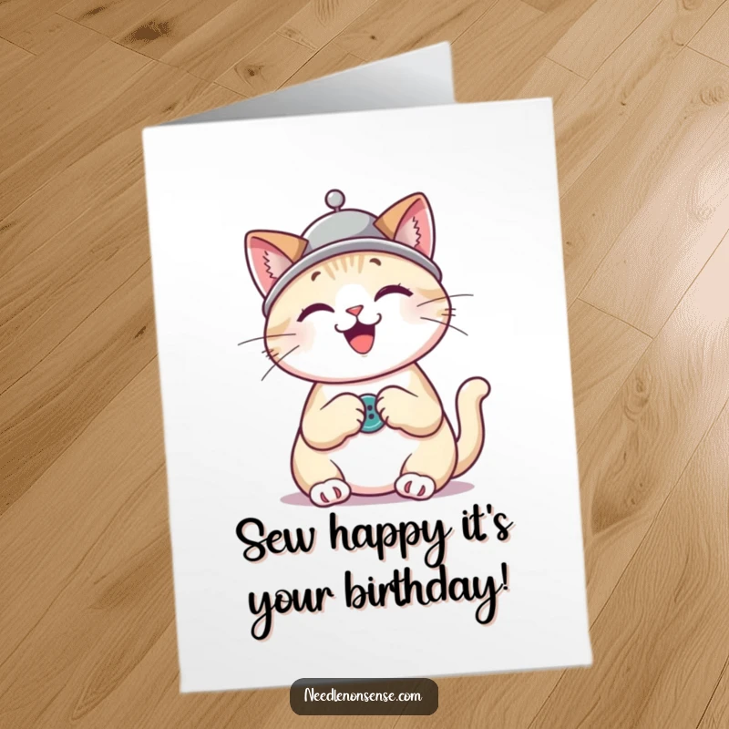 Funny Free Printable Birthday Card: Cheerful cat wearing a thimble hat, diligently sewing a button with a needle.