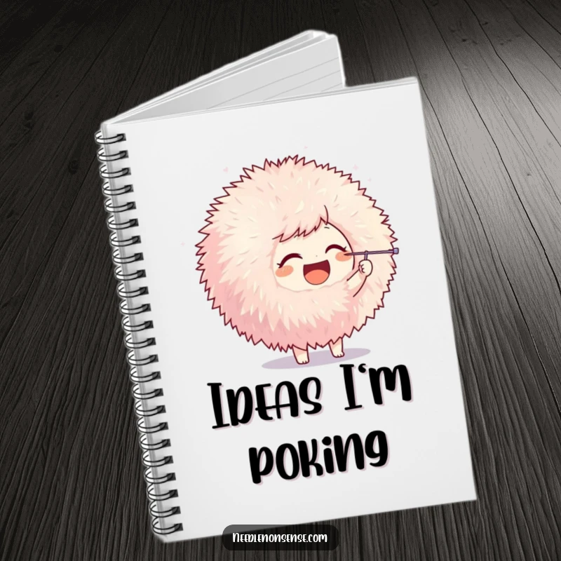 Funny notebook with a joyful character poking a giant pom-pom with a needle, perfect for notes and creative inspiration with humor.