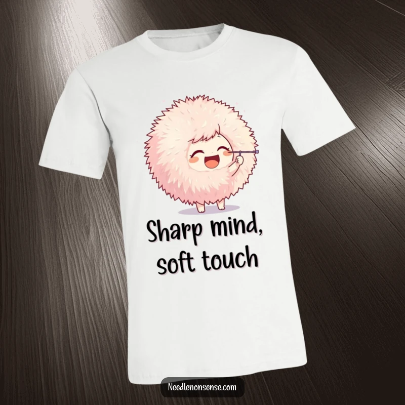 Funny t-shirt depicting a joyful character poking a giant fluffy pom-pom with a needle, illustrating playful crafting.