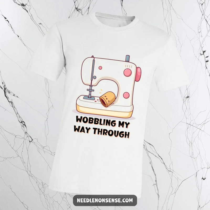Funny t-shirt depicting a sewing thimble with a comical wobble falling off a sewing machine, great for sewing enthusiasts.